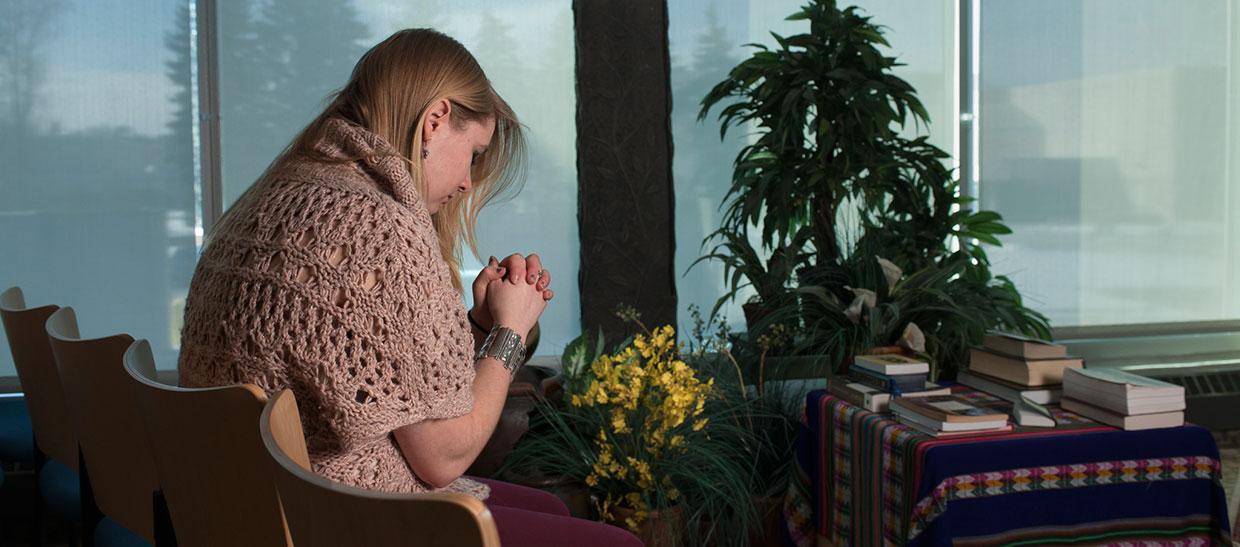 Student praying in prayer room on campus